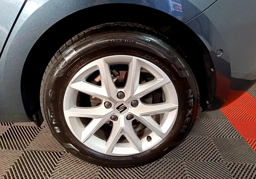 Gros plan sur la roue avant droite grise d'une SEAT LEON 2023 avec jante alliage à 5 doubles branches.