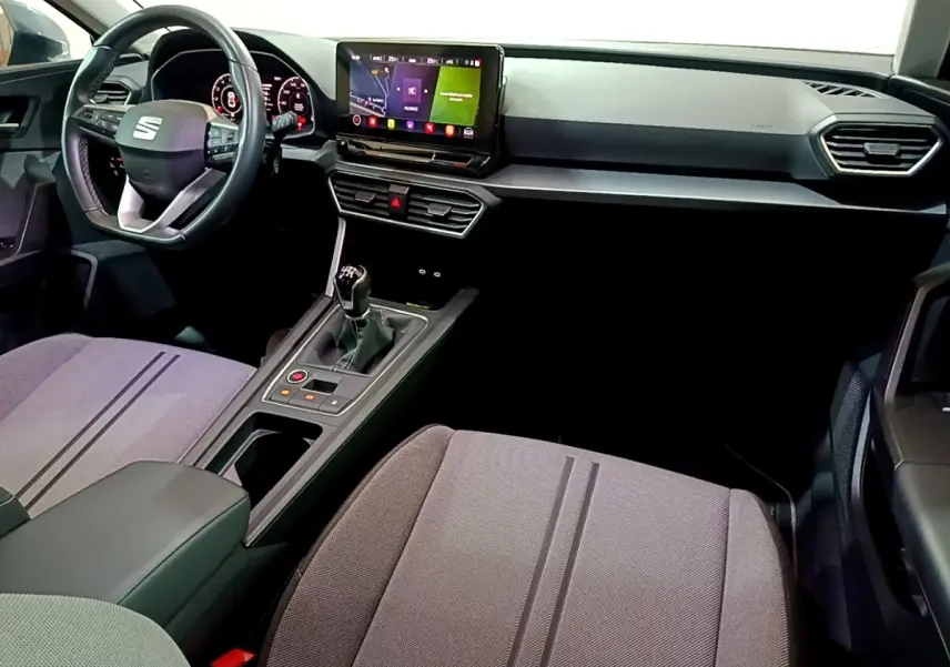 Vue intérieure avant droite du tableau de bord et console centrale d'une SEAT Leon gris clair avec boîte manuelle et écran tactile.