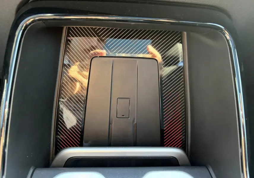 Détail de la console centrale du BMW X1 noir Saphir 2025, avec surface à motifs diagonaux et recharge par induction.