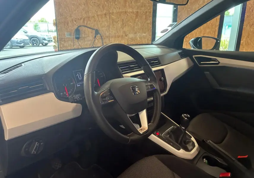 Intérieur du SEAT Arona 1.0 TSI 110 XCELLENCE 2021, vue côté conducteur, tableau de bord noir avec inserts gris clair.