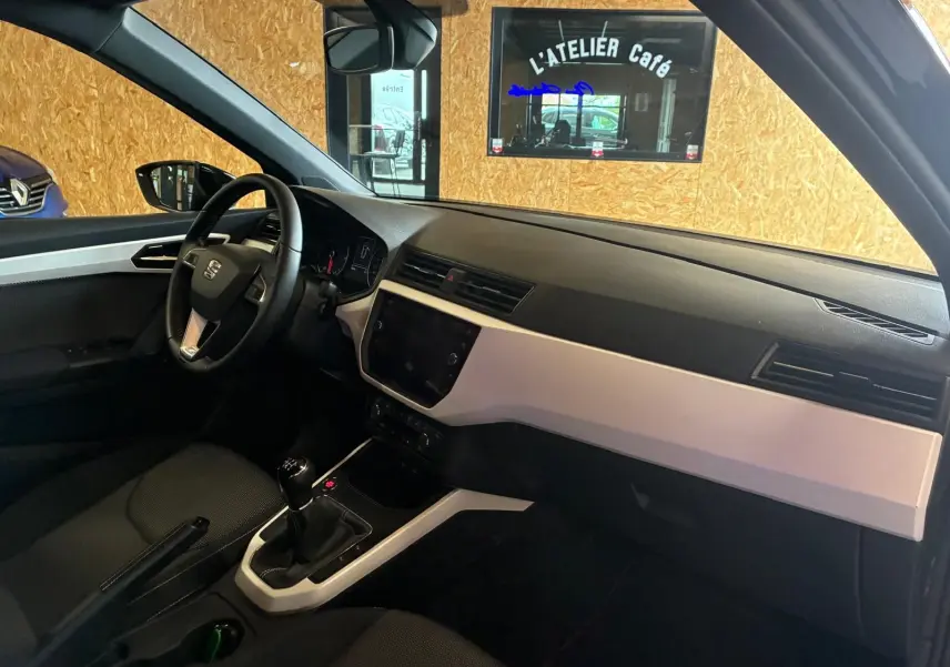 Intérieur avant droit du SEAT Arona gris foncé 2021, tableau de bord noir et beige avec boîte manuelle visible.