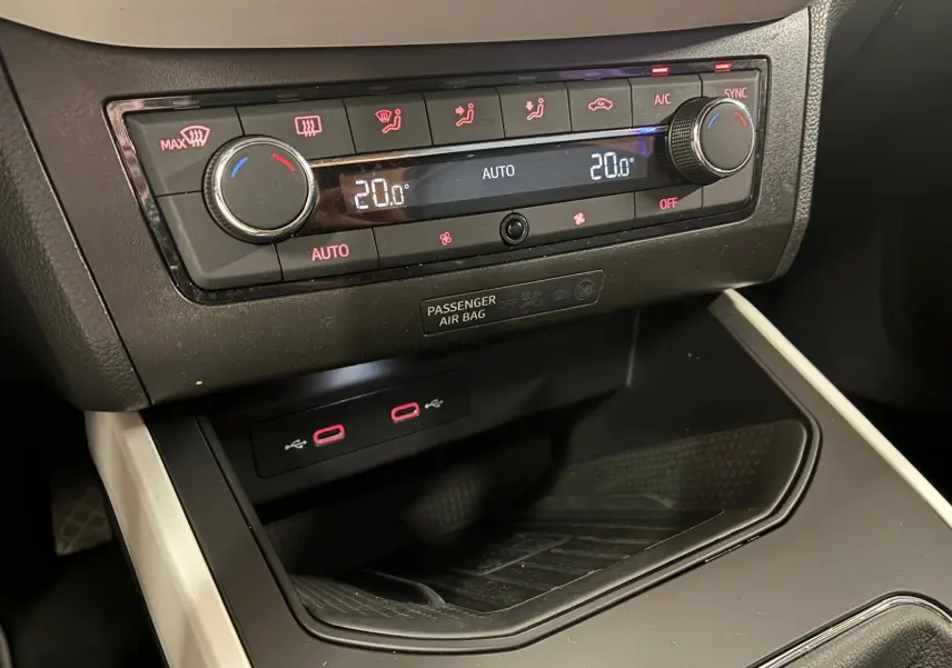 Gros plan sur la console centrale du SEAT Arona 2021, montrant la climatisation digitale et ports USB rouges.