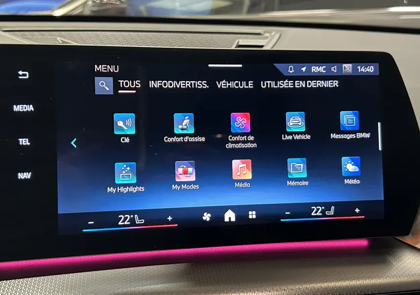 Écran tactile central du BMW X1 2024 affichant le menu principal avec ambiance lumineuse intérieure rose visible.