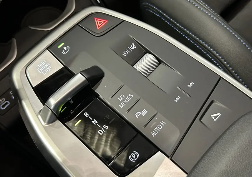 Gros plan sur la console centrale du BMW X1 M Sport 2024 avec levier de vitesse automatique et commandes multifonctions.