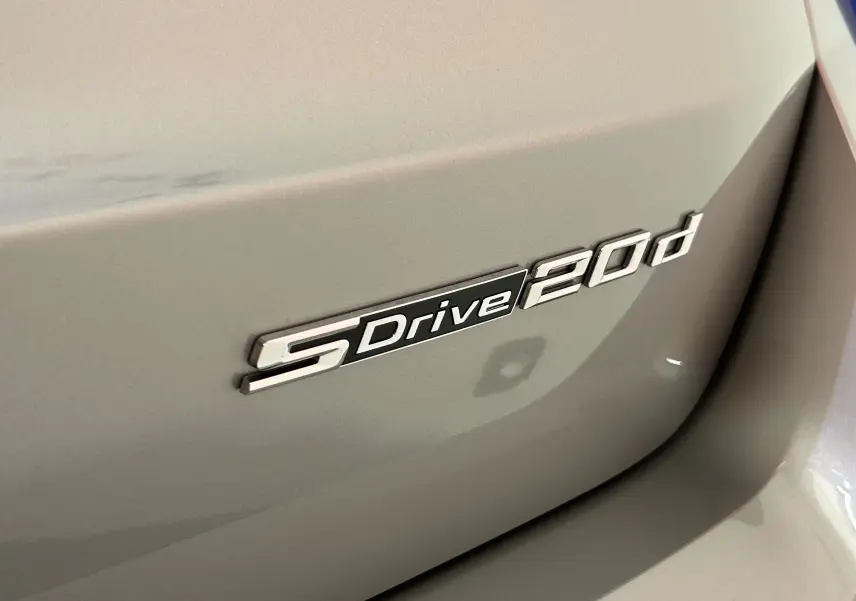 Gros plan sur l’inscription SDrive 20d sur la carrosserie argent Spacesilber d’un BMW X1 2024.