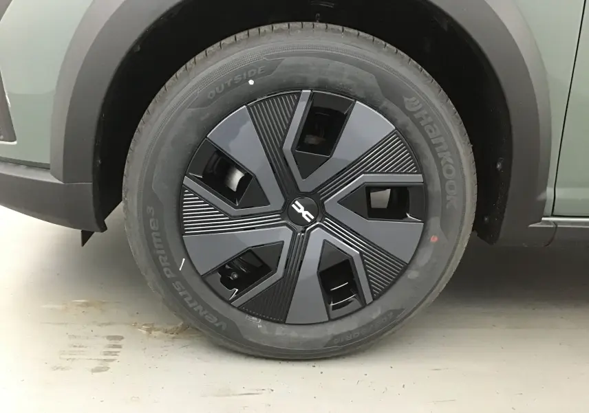 Gros plan sur la roue avant gauche de la Dacia Sandero Stepway 2025 kaki avec jante noire au design moderne.