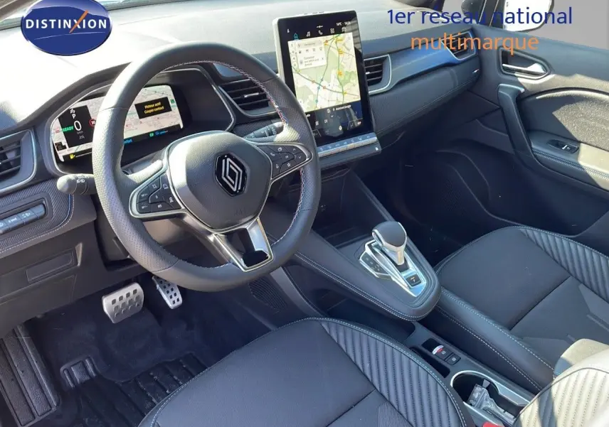 Intérieur du Renault Captur E-Tech Hybrid 2025, vue du poste de conduite avec volant multifonction et écran tactile vertical.