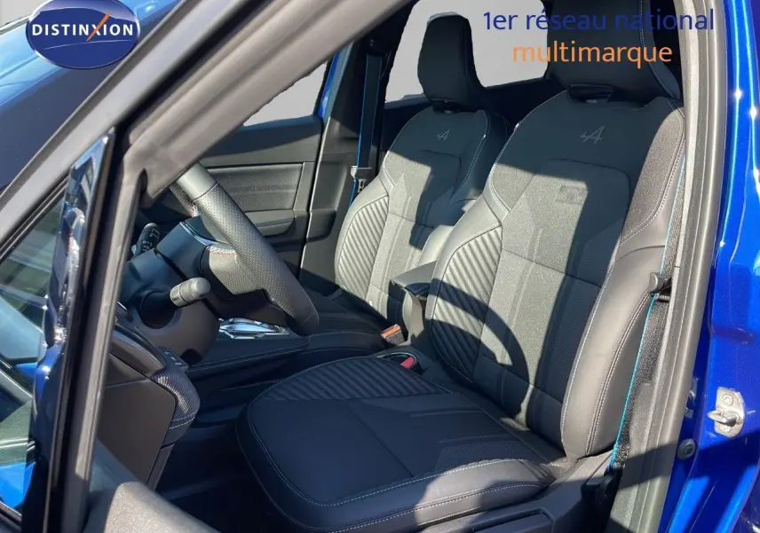 Intérieur avant droit du Renault Captur E-Tech hybride 2025 avec sièges noirs au logo Alpine, porte ouverte bleu iron metal.