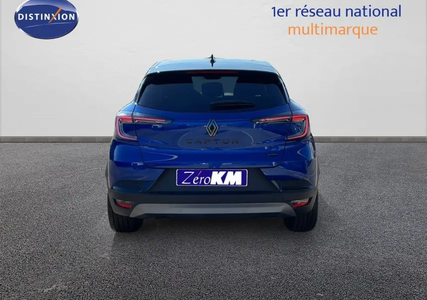 Vue arrière du Renault Captur E-Tech hybride 2025 en bleu Iron Metal avec toit noir, sur fond neutre.