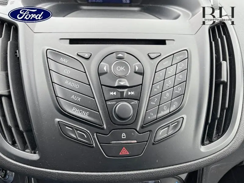 Vue rapprochée du tableau de bord noir du Ford Kuga 2015, mettant en valeur la console centrale avec commandes multimédia.