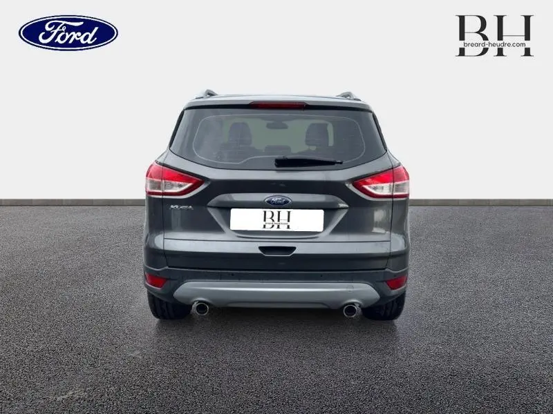 Vue arrière d'un Ford Kuga gris Magnetic de 2015 avec double sortie d'échappement et feux arrière allongés.