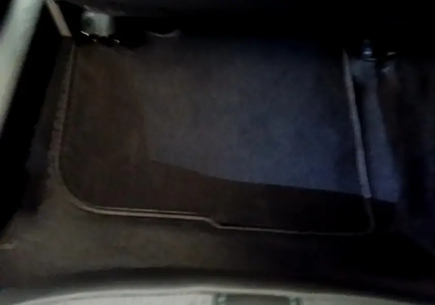Tapis de sol noir en tissu dans l'habitacle avant d'un Peugeot 2008 gris clair, vue plongeante intérieure.