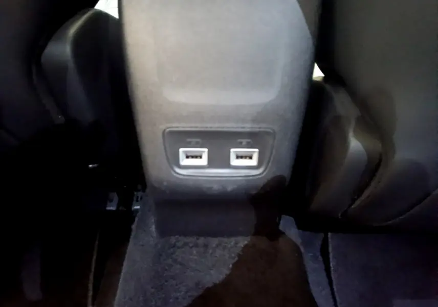 Prise USB double vue en gros plan à l'arrière du siège central d'un Peugeot 2008 gris clair 2021.