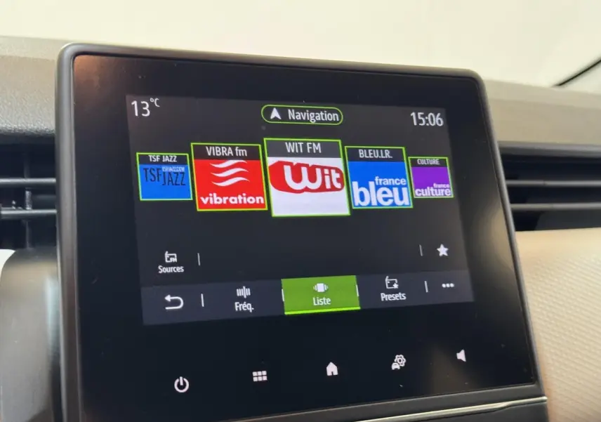 Écran tactile central de la Renault Clio Business blanc, affichant les stations radio et la navigation à 15h06.