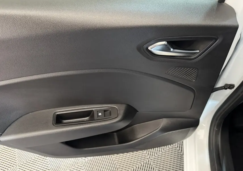 Vue intérieure côté gauche de la porte avant blanche d'une Renault Clio Business TCe 100 GPL avec poignée et commande de verrouillage.