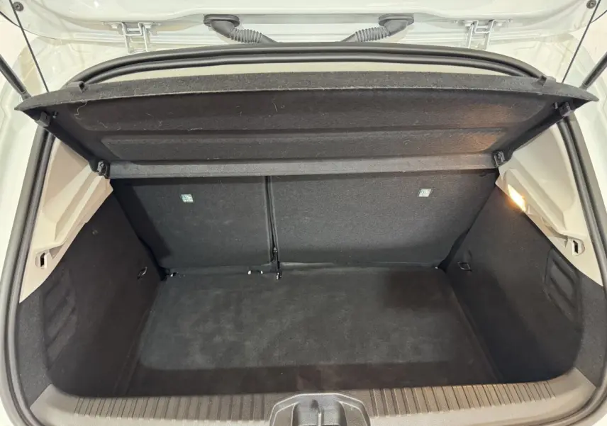 Coffre ouvert vu de l'arrière d'une Renault Clio Business blanc, espace de chargement propre et vide avec éclairage intérieur.