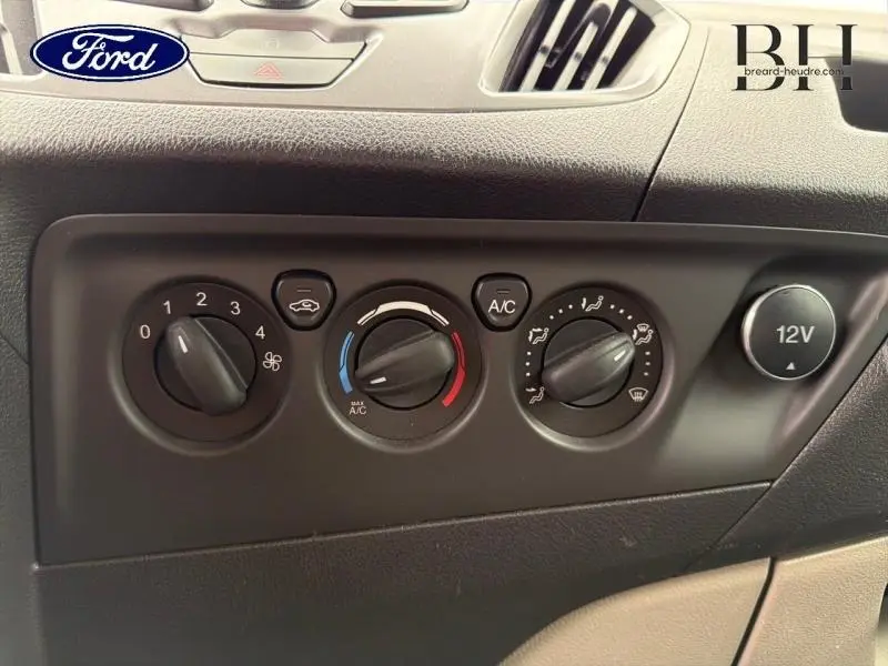 Vue rapprochée du tableau de commande de climatisation et prise 12V du Ford Transit Custom noir de 2013.