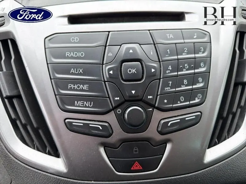 Vue rapprochée du tableau de bord du Ford Transit Custom noir, montrant les commandes audio et radio centrales.