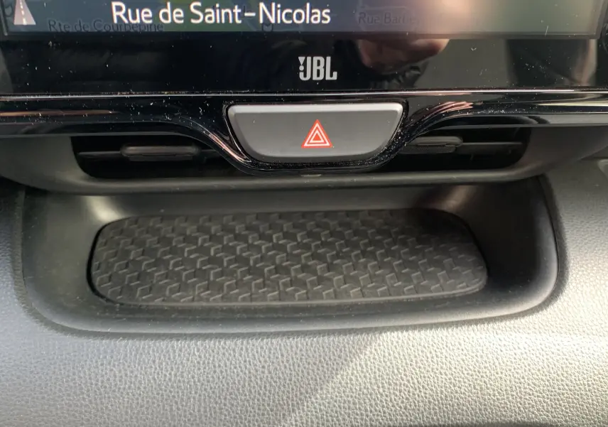 Détail du tableau de bord de la Toyota Yaris 2021 montrant le bouton de warning et l'écran GPS avec logo JBL.