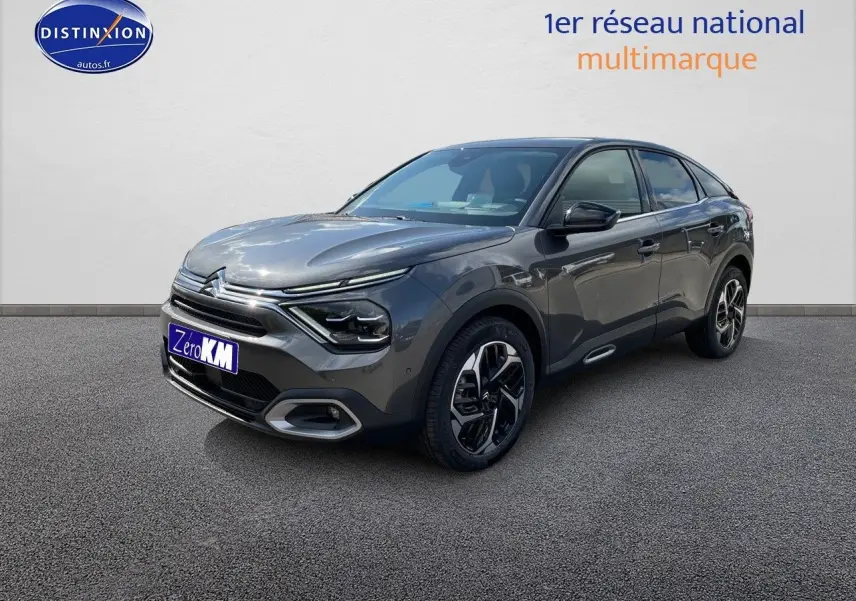 Citroën C4 gris platinium métal vue 3/4 avant droit, avec calandre distinctive et jantes bi-ton modernes.