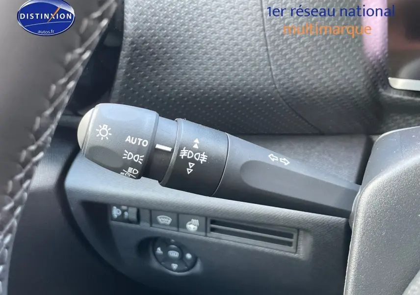 Gros plan sur la commande des feux et clignotants à gauche du volant dans un Citroën C4 gris platinium 2024.