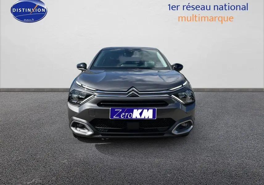 Vue frontale d'une Citroën C4 2024 gris platinium métal avec calandre distinctive et feux LED fins.