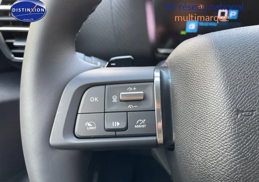 Gros plan sur les commandes au volant en cuir noir du Citroën C4 2024 gris platinium métal, version essence automatique.