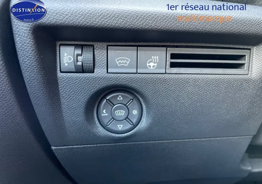 Détail des commandes côté gauche du tableau de bord de la Citroën C4 gris platinium 2024, avec réglage phares et dégivrage.