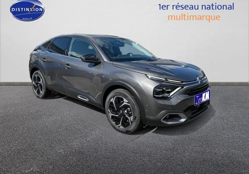 Citroën C4 gris platinium métal en 3/4 avant droit, avec jantes bicolores et feux LED distinctifs.