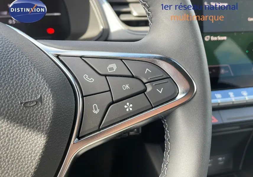 Gros plan sur les commandes multifonctions à droite du volant du Renault Captur noir étoile métal avec toit gris, intérieur moderne.