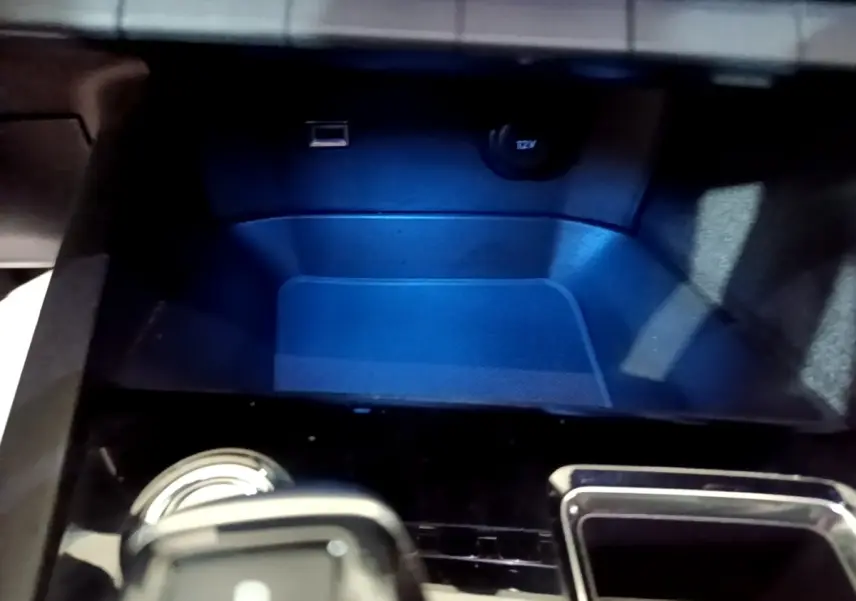Gros plan sur la console centrale du Peugeot 3008 GT bleu, montrant prise USB et prise 12V avec éclairage bleu.