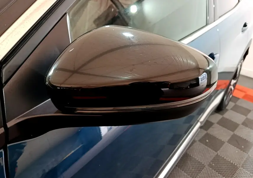 Rétroviseur noir brillant côté gauche du Peugeot 3008 PureTech 130 GT bleu, vue rapprochée en intérieur.