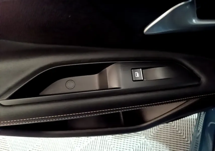 Gros plan sur la poignée intérieure côté gauche en cuir noir avec bouton de verrouillage, Peugeot 3008 bleu 2021.