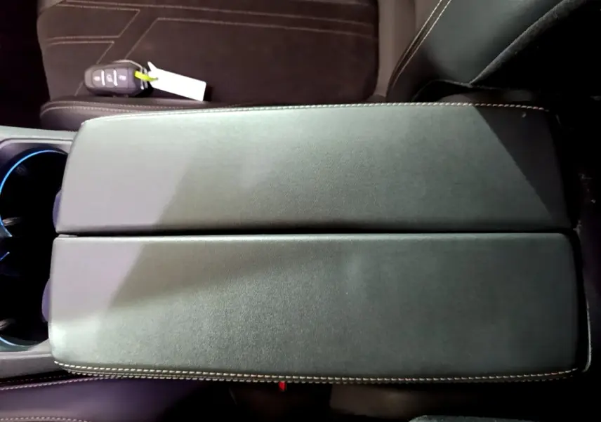 Vue plongeante sur l'accoudoir central en cuir noir avec surpiqûres contrastantes du Peugeot 3008 bleu PureTech 2021.