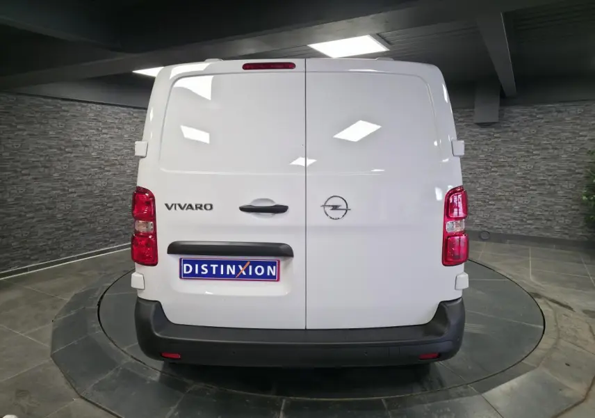 Vue arrière d'un Opel Vivaro blanc avec portes battantes et pare-chocs noirs dans un showroom.