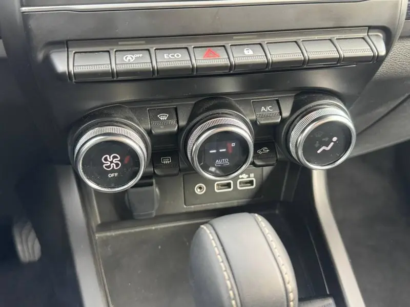 Vue rapprochée de la console centrale du Renault Arkana 2025 montrant les commandes de climatisation et boutons fonctionnels.