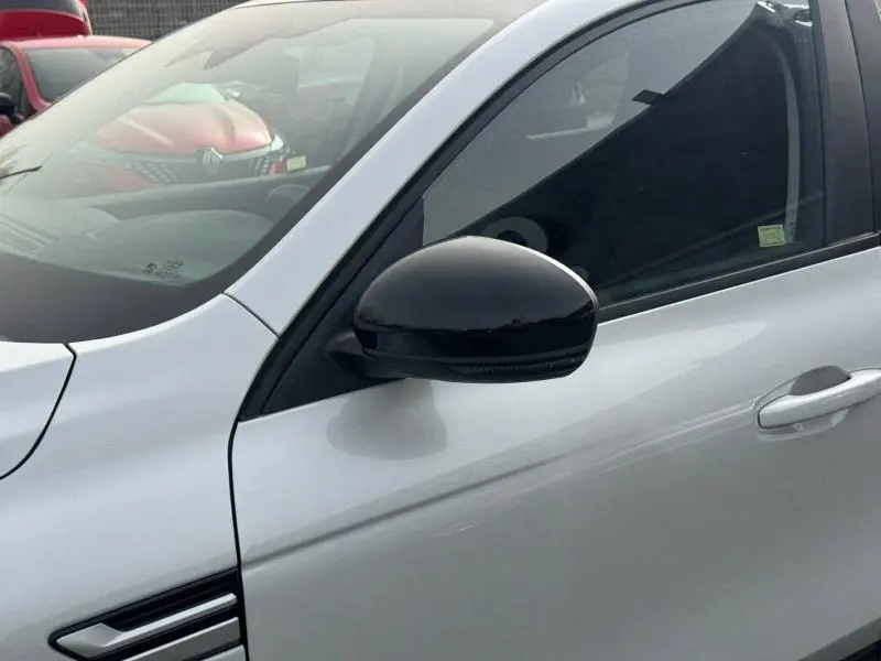 Gros plan sur le rétroviseur noir et la portière côté gauche d’un Renault Arkana blanc 2025, version hybride.
