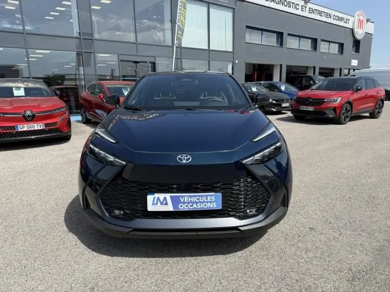 Vue avant du Toyota C-HR Hybride 2024 bleu persan, avec calandre noire et logo Toyota bien visible.