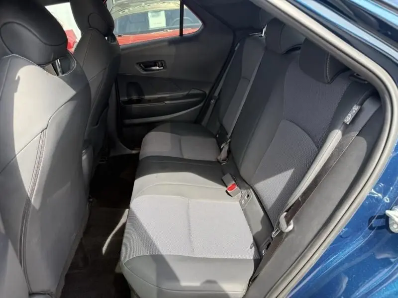 Vue intérieure de la banquette arrière côté droit du Toyota C-HR Hybride 2024 en bleu persan, sièges tissu gris et noir.