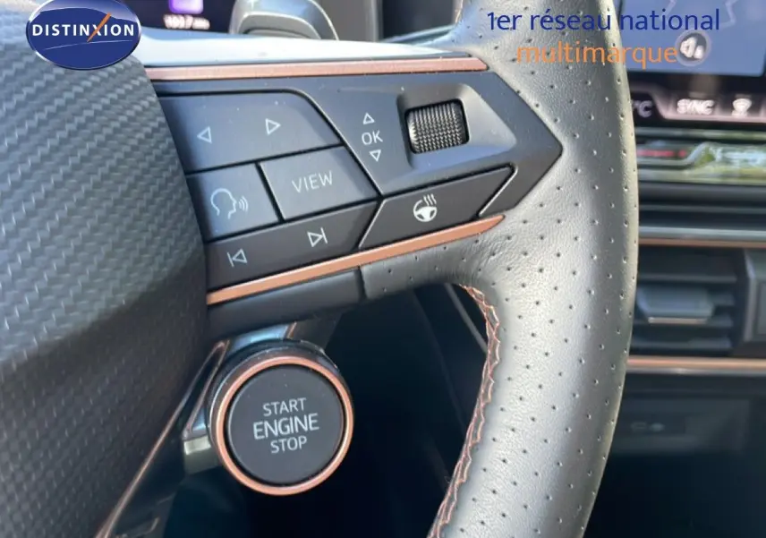 Gros plan sur le volant cuir perforé avec commandes intégrées et bouton start engine stop du CUPRA Leon bleu Fjord.
