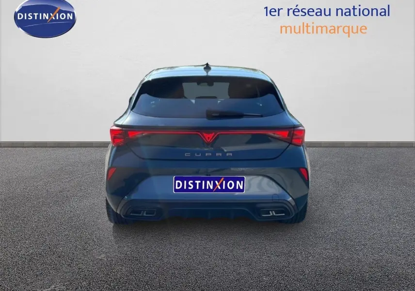 Vue arrière d'une CUPRA Leon 1.5 eTSI 150CH DSG en bleu Fjord, soulignant ses feux arrière LED et double sortie d'échappement.