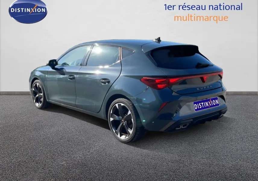 Vue 3/4 arrière droite d'une CUPRA Leon 1.5 eTSI 150CH DSG bleu Fjord avec jantes noires bicolores.