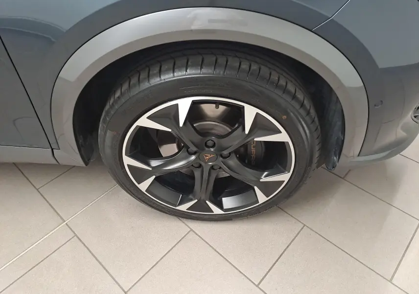 Gros plan sur la roue avant droite du CUPRA Formentor 1.4 e-HYBRID 245 DSG6 VZ gris magnétique avec jante noire et argentée.