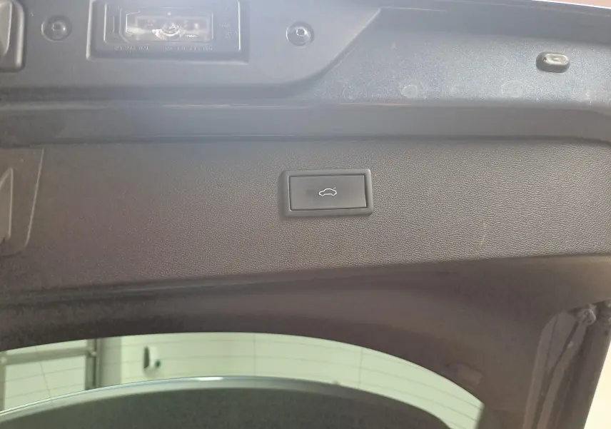 Bouton d'ouverture électrique du coffre sur la trappe intérieure d'une CUPRA Formentor gris magnétique 2024.