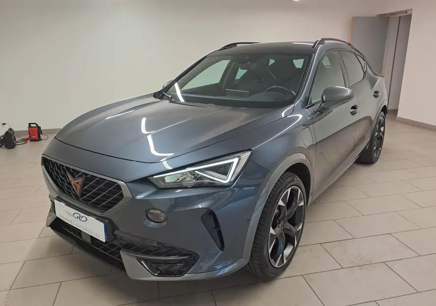Vue 3/4 avant droit du CUPRA Formentor gris magnétique 2024 avec jantes noires et calandre distinctive.