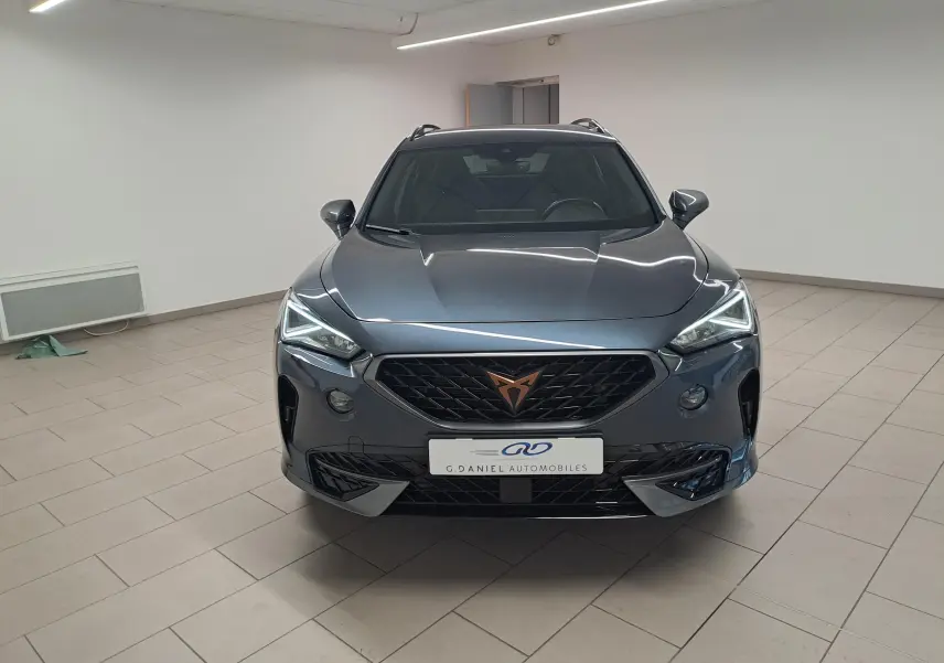 Vue frontale du CUPRA Formentor 1.4 e-HYBRID 245 DSG6 VZ gris magnétique, avec calandre noire et logo cuivré visible.
