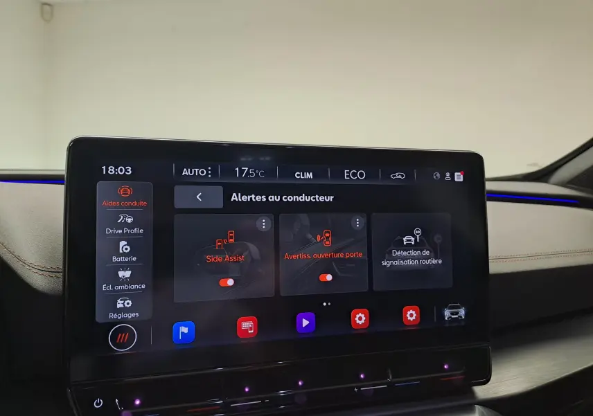 Écran tactile intérieur du CUPRA Formentor 2024 affichant les alertes au conducteur dans un habitacle beige avec éclairage d’ambiance bleu.