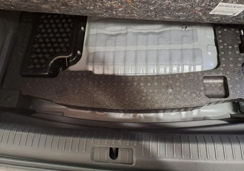 Détail du coffre du CUPRA Formentor 1.4 e-HYBRID 245 DSG6 VZ 2024, montrant la zone sous le plancher de chargement gris métallique.