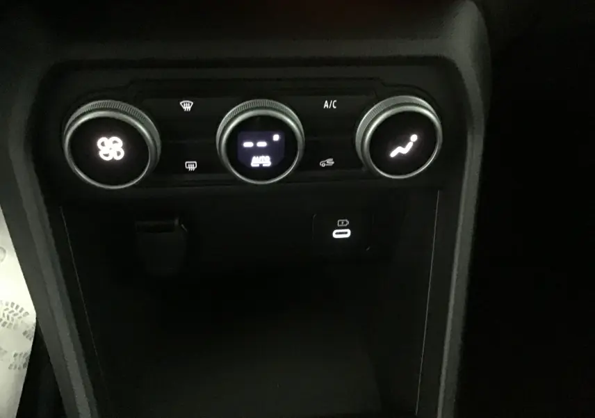 Commandes de climatisation automatique et prise USB du tableau de bord de la Dacia Sandero Stepway gris schiste 2025.