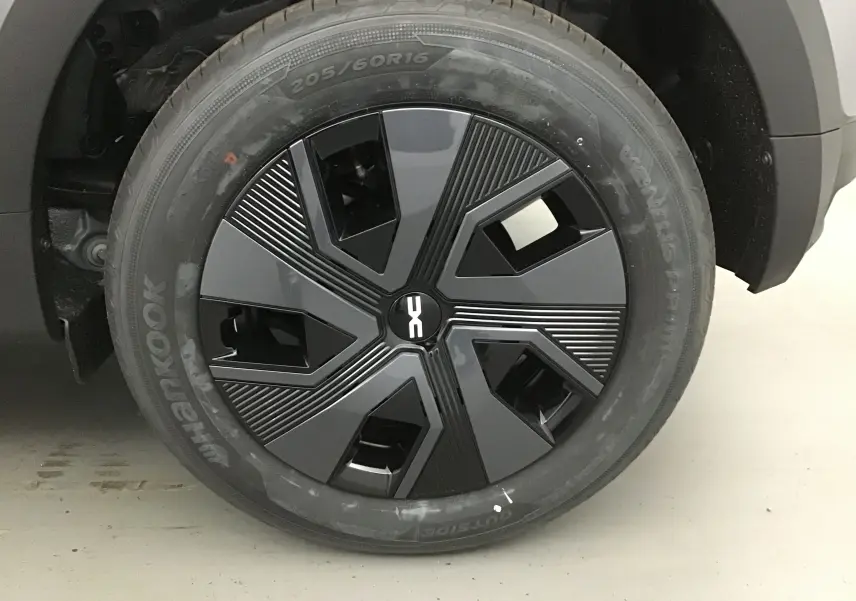 Gros plan sur la roue avant droite de la Dacia Sandero Stepway 2025 en gris schiste, avec jante au design moderne noir et gris.